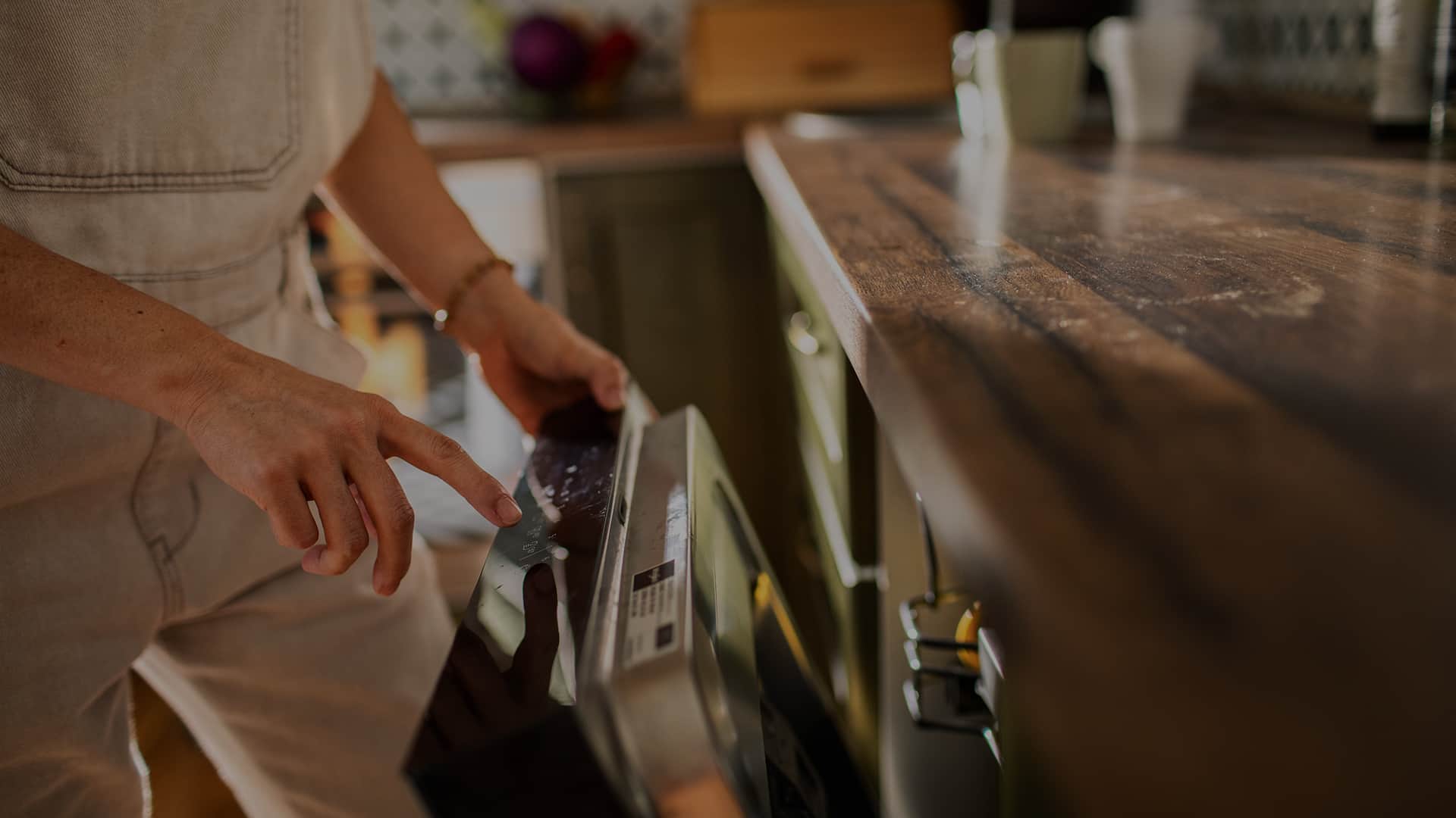 Osoba uruchamiająca zmywarkę w zabudowie kuchennej