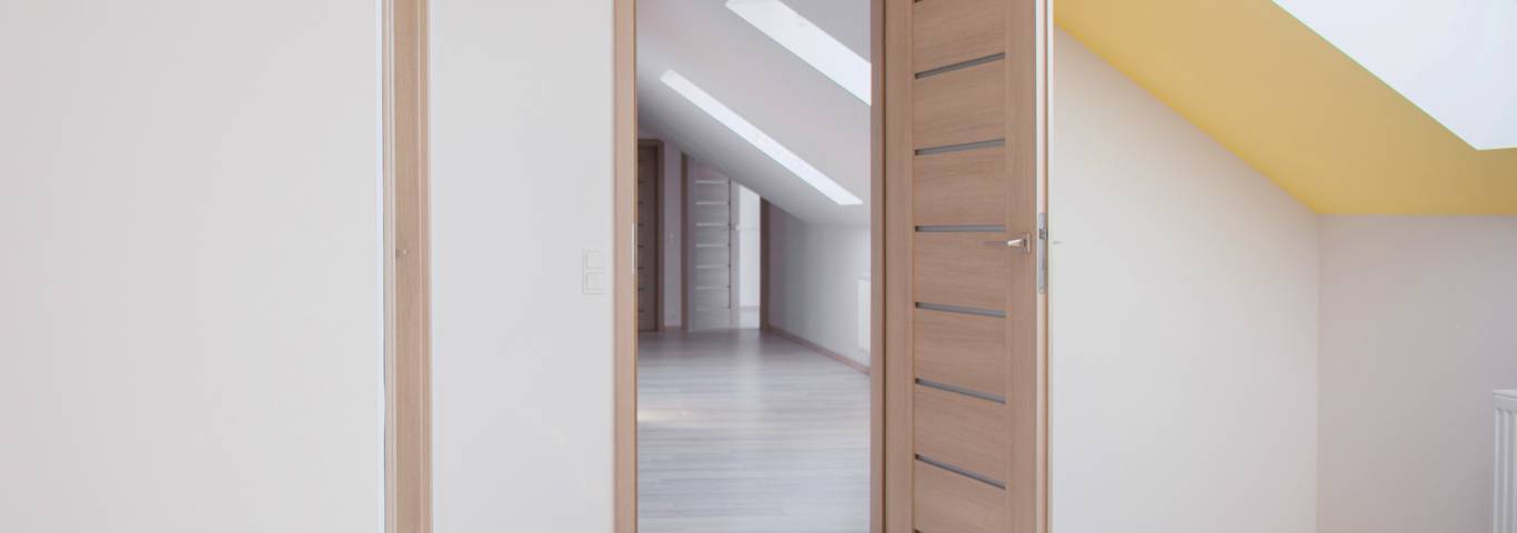 otwarte drewniane drzwi pokoju w domu wykończonym pod stan deweloperski