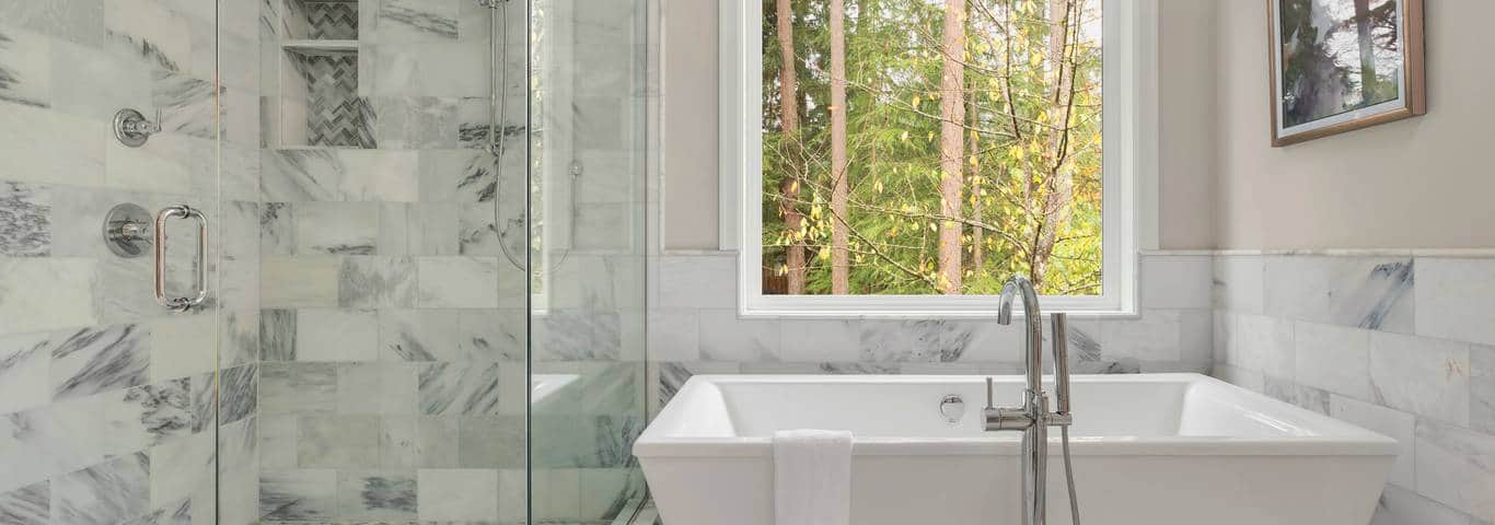 wnętrze łazienki z wanną prysznicem i oknem łazienkowym z widokiem