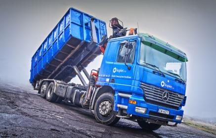 Samochód ciężarowy z zabudową hakową do transportu kontenerów, wyposażony w dźwig hydrauliczny 