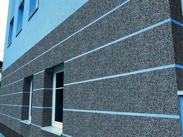 Elewacja budynku pokryta mozaikowym tynkiem akrylowym w odcieniach szarości i brązu, z poziomymi pasami jasnego błękitu.