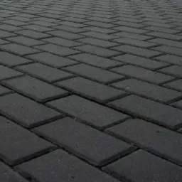 Ułożona szara kostka brukowa Holland 6cm w jodełkę, widok z niskiej perspektywy, lekko przyciemnione światło.