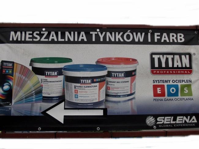 Baner reklamowy mieszalni tynków i farb, prezentujący puszki z tynkiem cienkowarstwowym, farbą elewacyjną i gruntem systemu marki Tytan, obok wachlarz kolorów.