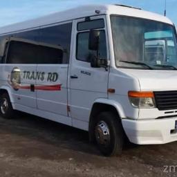 Trans Rd - Biały Mercedes-Benz bus z logo 'TRANS RD' na boku, zaparkowany na żwirowym podłożu, z widocznymi innymi autobusami w tle.