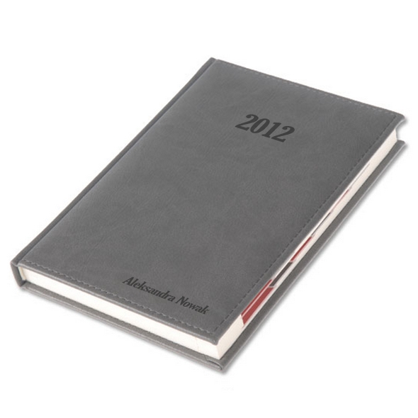 Szary kalendarz książkowy na rok 2012 z imieniem i nazwiskiem 'Aleksandra Nowak' wygrawerowanym na okładce, leżący na białym tle.