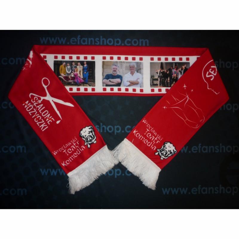Czerwony szalik z białymi frędzlami, motywami teatralnymi i logo 'Szalonych Nożyczek' Teatru Komedia we Wrocławiu, prezentujący zdjęcia z przedstawień i aktorów.