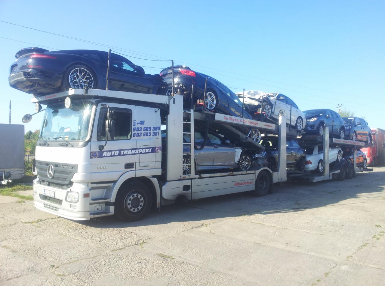 Laweta Mercedes-Benz przewozi uszkodzone samochody osobowe na dwupoziomowej platformie. Widoczny numer telefonu i napis AUTO TRANSPORT.