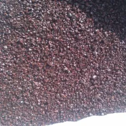 Worek wypełniony brązowym, błyszczącym granulatem paliwa stałego; widoczne refleksy świetlne na powierzchni.