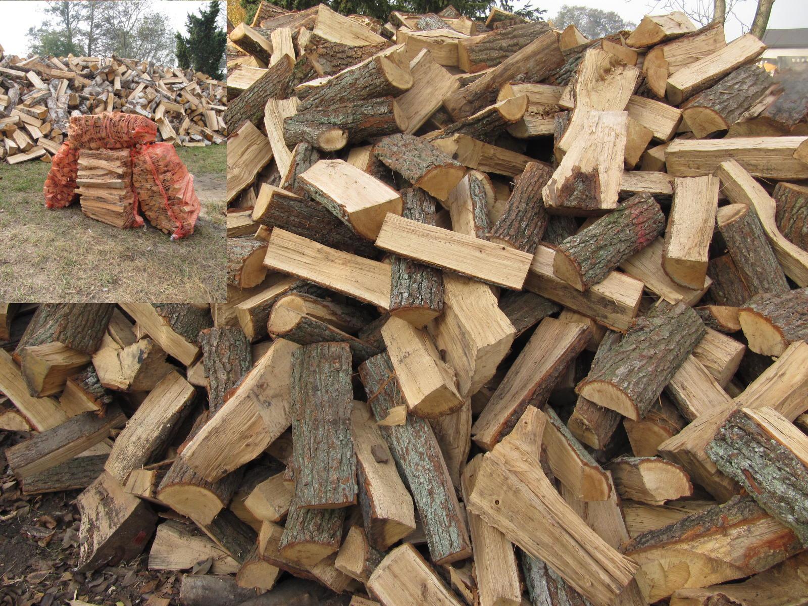 Stos nasypowego drewna opałowego z widoczną korą, w tle worki z drewnem i większy pryzmat drewna.
