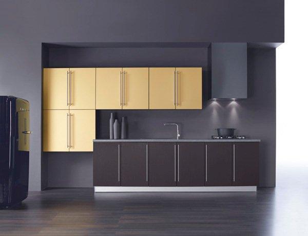 Nowoczesna kuchnia z ciemnymi, dolnymi szafkami, złotymi górnymi szafkami i czarną lodówką w stylu retro.