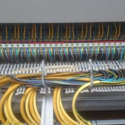 Elektromeister Kaminski - Rozdzielnica elektryczna z uporządkowanymi kablami w różnych kolorach, przymocowanymi opaskami zaciskowymi.