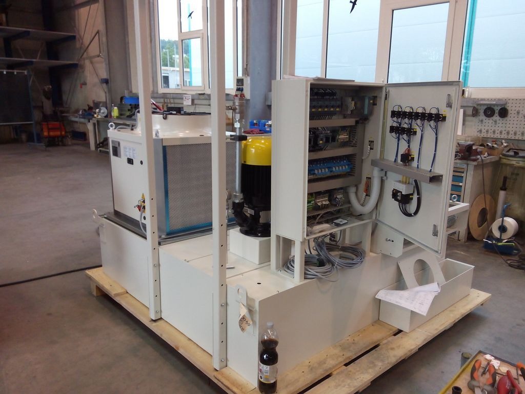 Rozdzielnica elektryczna z otwartymi drzwiami ukazująca wewnętrzne okablowanie i komponenty, umieszczona na palecie w warsztacie.