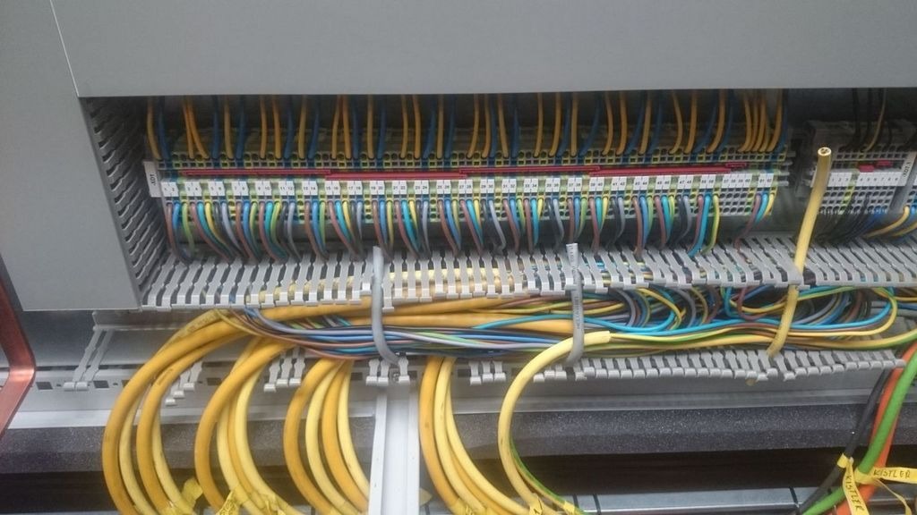 Rozdzielnica elektryczna z uporządkowanymi kablami w różnych kolorach, przymocowanymi opaskami zaciskowymi.