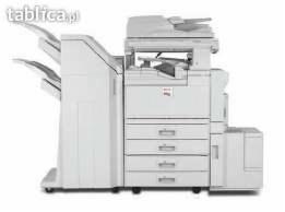 Biała, wielofunkcyjna kserokopiarka biurowa z podajnikiem arkuszy i wieloma szufladami na papier, ustawiona na białym tle.