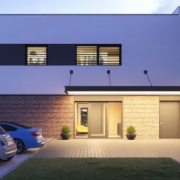 Nowoczesny dom jednorodzinny z elewacją z cegły klinkierowej i białymi panelami, widoczne dwa samochody na podjeździe i oświetlony wjazd do budynku.