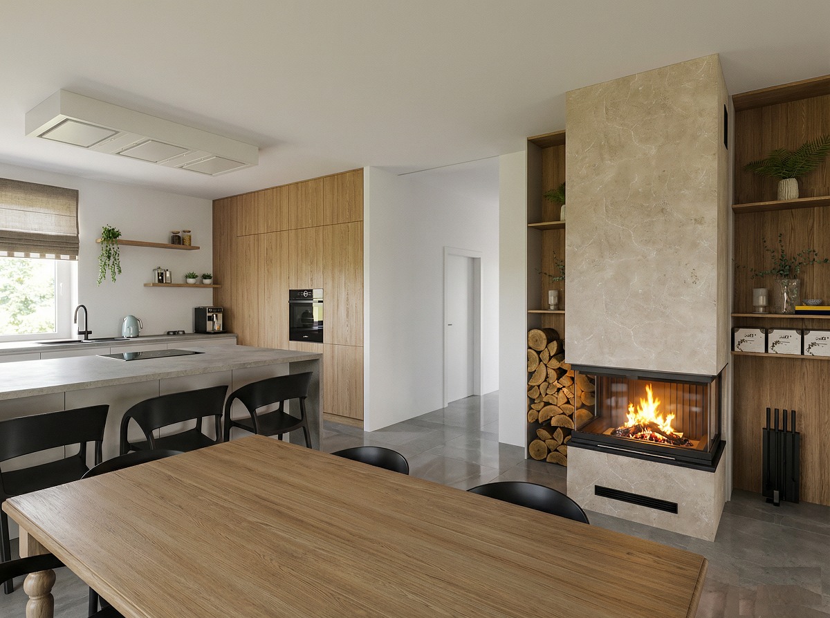 Nowoczesna kuchnia z wyspą i kominkiem narożnym obudowanym beżowym kamieniem. Drewniane szafki kuchenne i stół. Na półkach dekoracje i drewno do kominka.