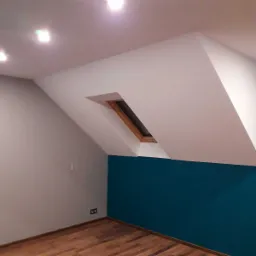 Pomalowane poddasze z oknem dachowym; ściana w kolorze petrolu, reszta ścian w odcieniach bieli i szarości, drewniana podłoga.