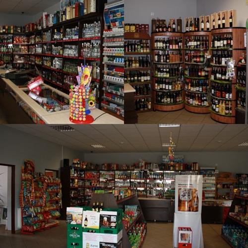 Wnętrze sklepu z alkoholem, półki pełne butelek wina, wódek i innych napojów, regały okrągłe i proste, w tle widoczne przekąski i słodycze.