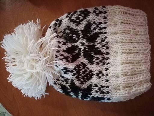 Ręcznie robiona, biało-czarna czapka z pomponem, widoczne detale dziergania