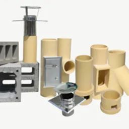 Zestaw elementów kominowych: bloczki betonowe, rury ceramiczne, wyczystka, daszki kominowe ze stali nierdzewnej, na jasnym tle.