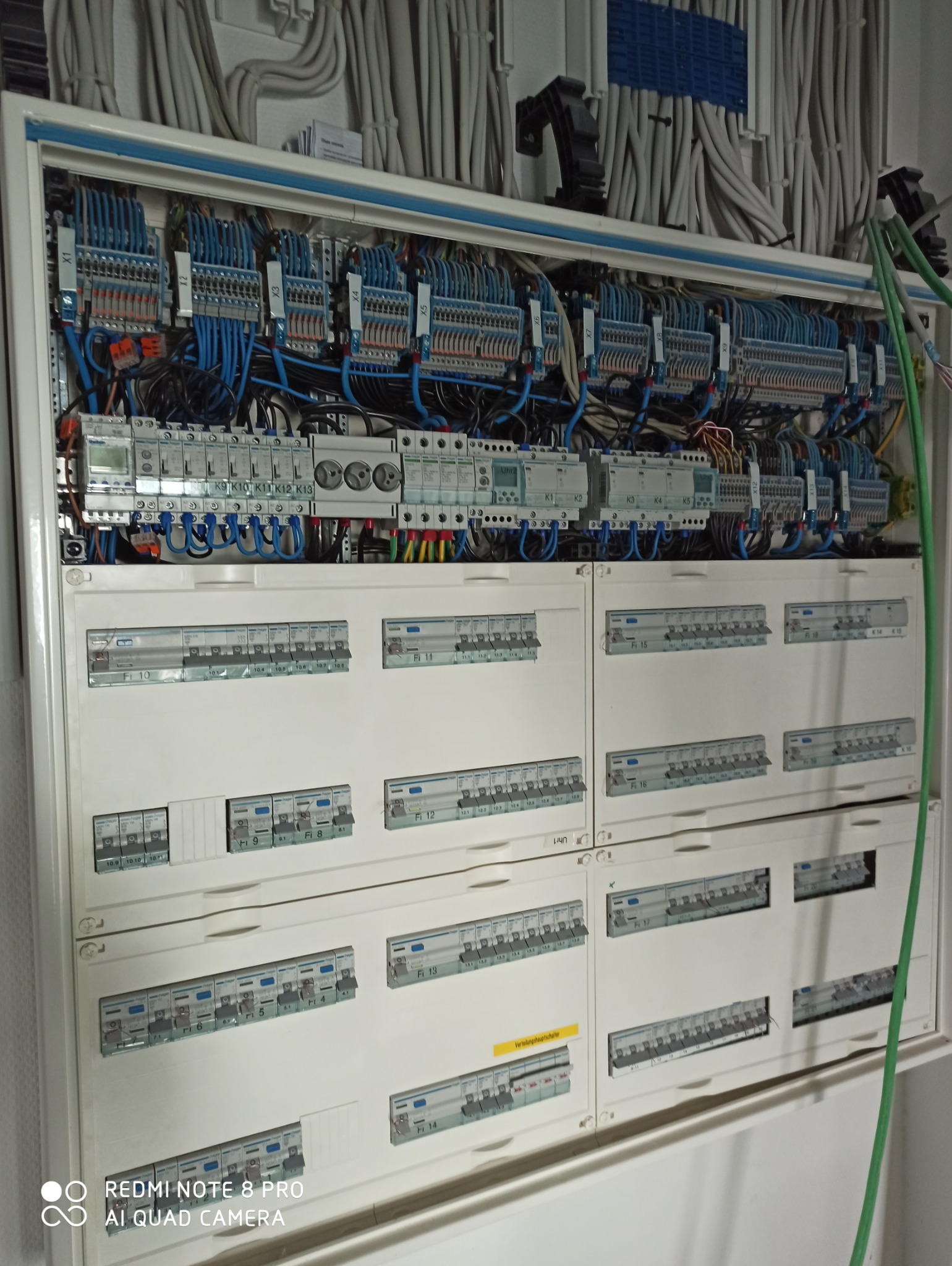 Rozdzielnia elektryczna po zakończonej instalacji w Kamieniu, widoczne liczne zabezpieczenia, przewody i listwy zaciskowe. U góry uporządkowane kable w peszlach.