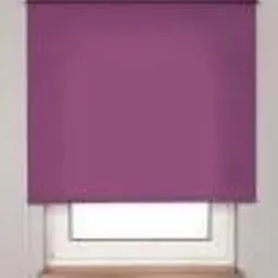 Zasłonięta roleta w odcieniu fuksji na oknie z białymi ramami, widoczny parapet z jasnego drewna.