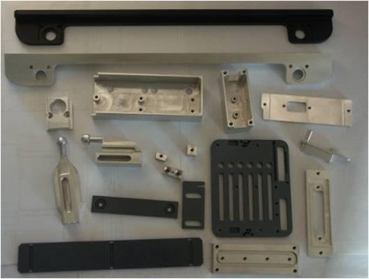 Zestaw precyzyjnie wykonanych, metalowych elementów o różnorodnych kształtach i rozmiarach, wyprodukowanych z aluminium i tworzywa sztucznego, leżących na jasnym tle, prezentujących detale obróbki...