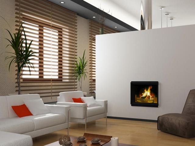 Jasne wnętrze salonu z drewnianymi żaluzjami, białymi meblami, kominkiem w ścianie i roślinami doniczkowymi.