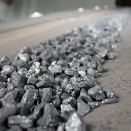 Węgiel kamienny, sortowany orzech, transportowany na taśmociągu w hali magazynowej, widok z bliska.