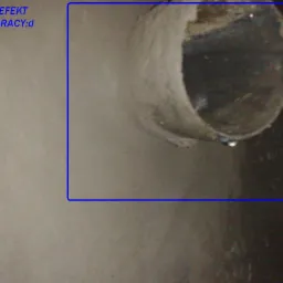 Przekrój betonowej rury z kroplą wody, widoczny z bliska, z napisem 'A TO JUZ EFEKT NASZEJ PRACY;d' u góry po lewej stronie.