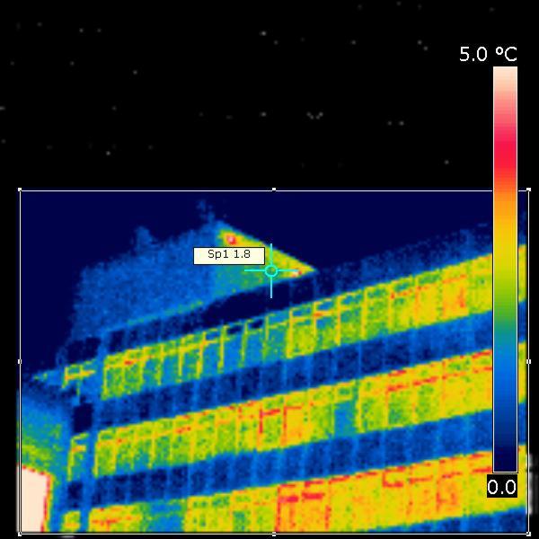 Termowizyjne zdjęcie budynku z zaznaczonym punktem pomiarowym Sp1 1.8 i skalą temperatur od 0.0 do 5.0 stopni Celsjusza, prezentujące rozkład ciepła.