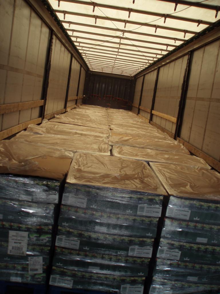 Wnętrze naczepy wypełnione paletami z kawą Jacobs Kronung 500g, zabezpieczonymi folią stretch i dodatkowymi arkuszami.