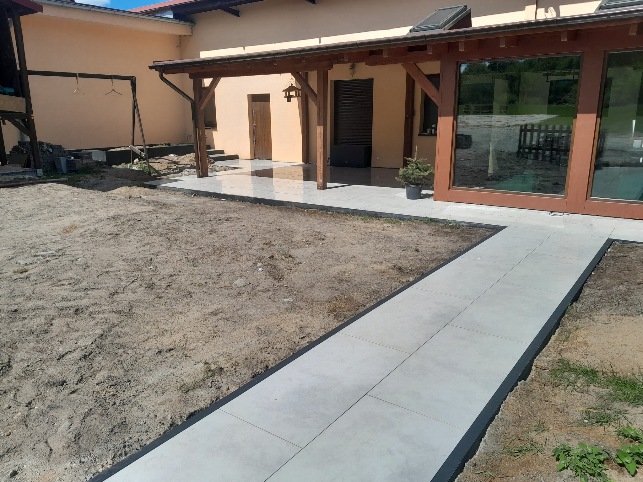 Taras plus wejście i opaska - wykonane z płyt gresowych.