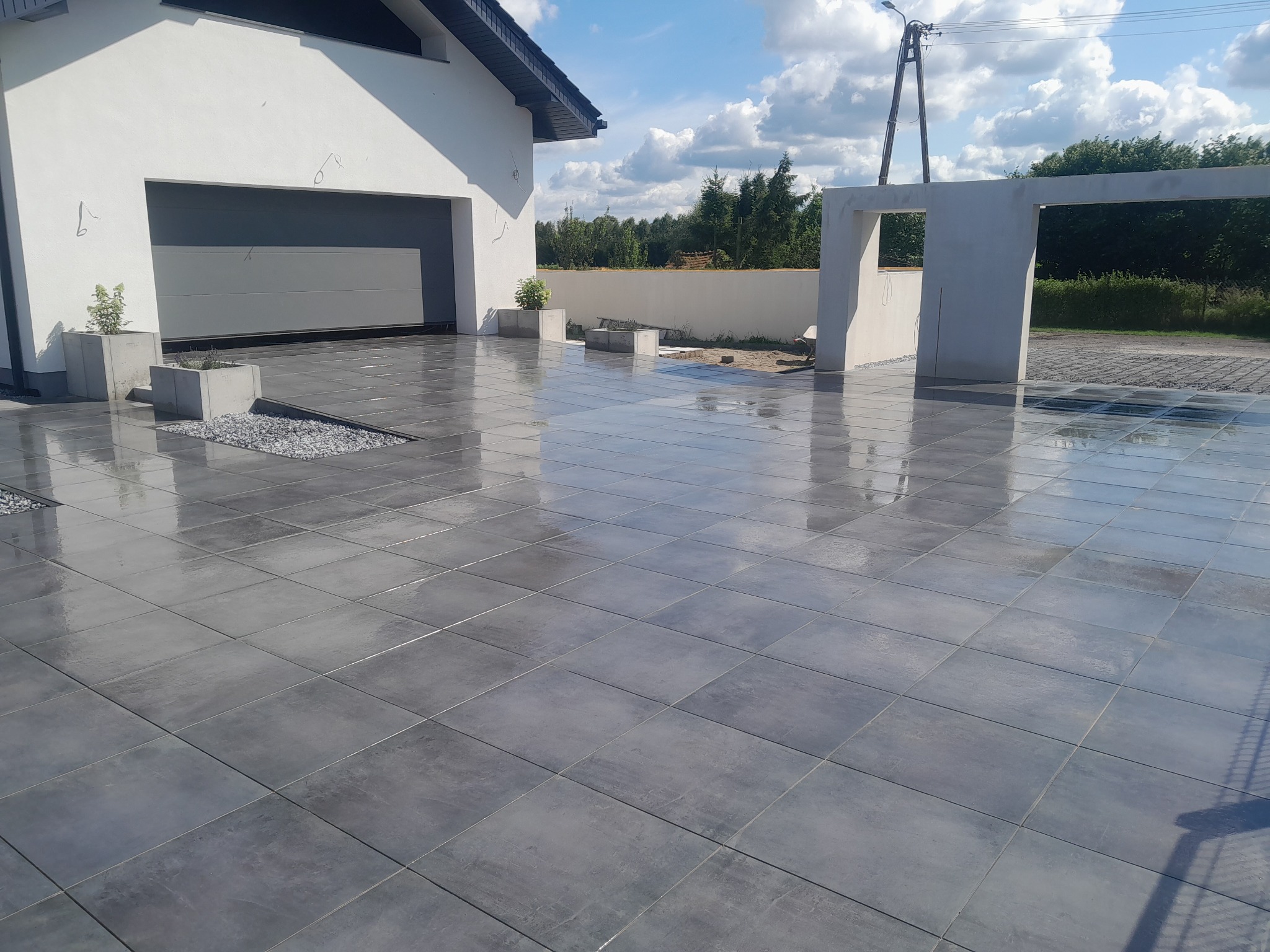 Podjazd plus parking wykonany z płyt gresowych.