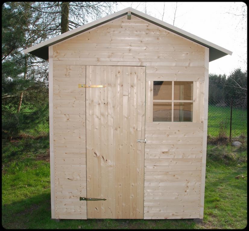 Mała drewniana szopa ogrodowa z oknem, wykonana z jasnego drewna, widoczna na tle trawnika i drzew.