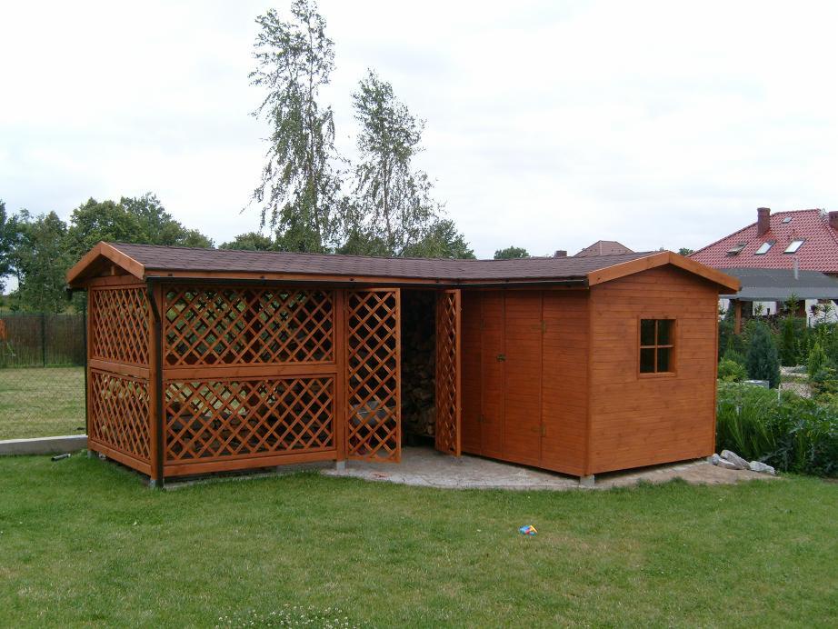 Drewniana pergola z kratownicą i przylegającą do niej szopa na narzędzia, brązowy dach, otwarte drzwi, trawnik, dom w tle.