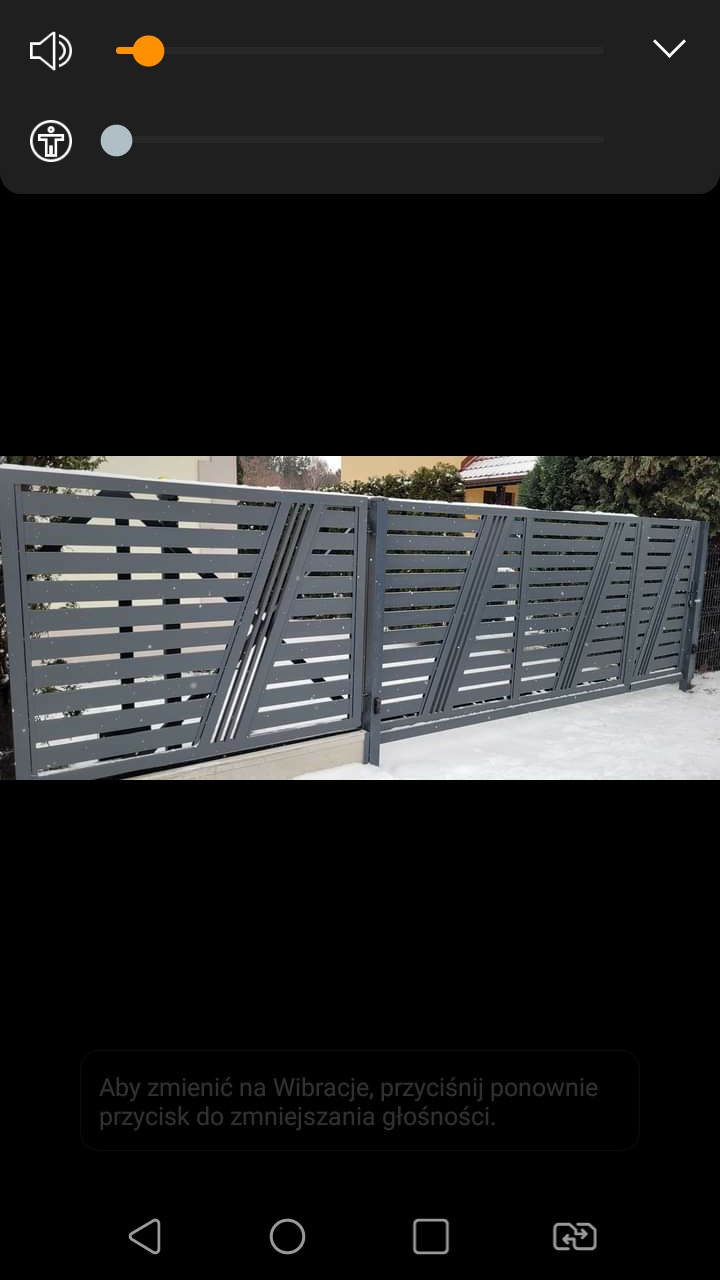 Nowoczesna, szara brama posesyjna z poziomymi panelami i ukośnymi akcentami, widoczna na tle zaśnieżonego ogrodu.