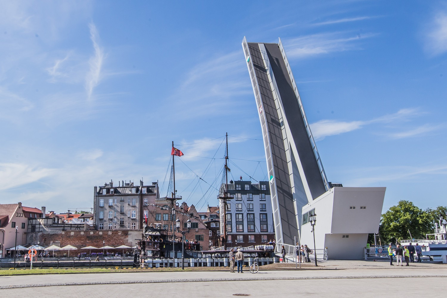 Otwarty most zwodzony w Gdańsku na tle zabudowy Starego Miasta i repliki statku pirackiego.