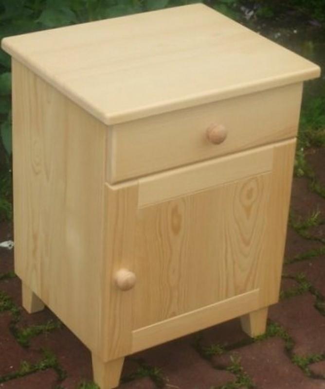 Drewniana szafka nocna z szufladą i drzwiczkami, wykonana z jasnego drewna, prezentowana na zewnątrz w Wiśle, z widocznymi detalami słojów drewna.