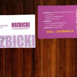 Projekt wizytówki firmy transportowej Rozbicki z danymi kontaktowymi i ofertą przewozów osobowych i ciężarowych, na drewnianym tle.