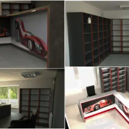 Nowoczesne biuro z regałami i recepcją, akcentowane czerwonymi detalami. Dekoracja z motywem samochodu sportowego. Stonowana kolorystyka, minimalistyczny design.