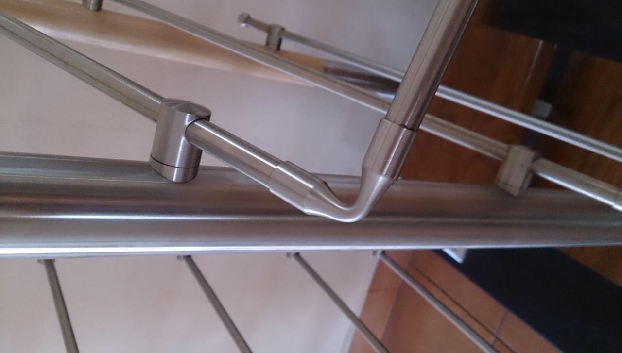 Szczegółowe ujęcie łączenia elementów metalowych balustrady ze stali nierdzewnej, widoczne mocowania i spawane połączenia.