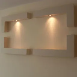 Dwa podświetlane, geometryczne wnęki ścienne wykonane z płyt gipsowo-kartonowych (G/K), tworzące nowoczesny element dekoracyjny na jednolitej, kremowej ścianie.