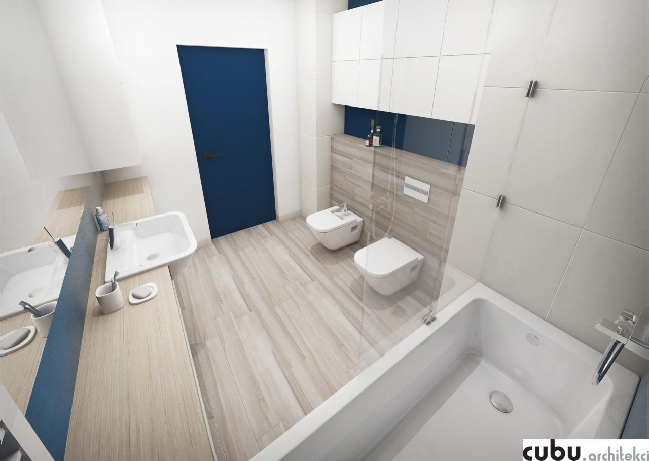 Nowoczesna łazienka z dwoma umywalkami na drewnianym blacie, białą wanną za szklaną ścianką, toaletą i bidetem, oraz szafkami wiszącymi nad płytkami imitującymi drewno, akcentowana niebieską ścianą...