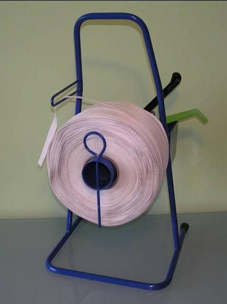 Duża rolka taśmy poliestrowej, wzdłużnie klejonej i tkanej, umieszczona na niebieskim metalowym stojaku z elementami zielonymi i czarnymi.