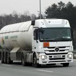 Axan Sp.z o.o. - Ciężarówka cysterna z pomarańczową tablicą ostrzegawczą przewożąca paliwo, widoczna na autostradzie, w tle las.