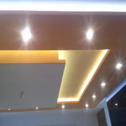 Nowoczesny sufit podwieszany z oświetleniem punktowym i wbudowanym oświetleniem LED, widoczne elementy konstrukcyjne przed ostatecznym wykończeniem.