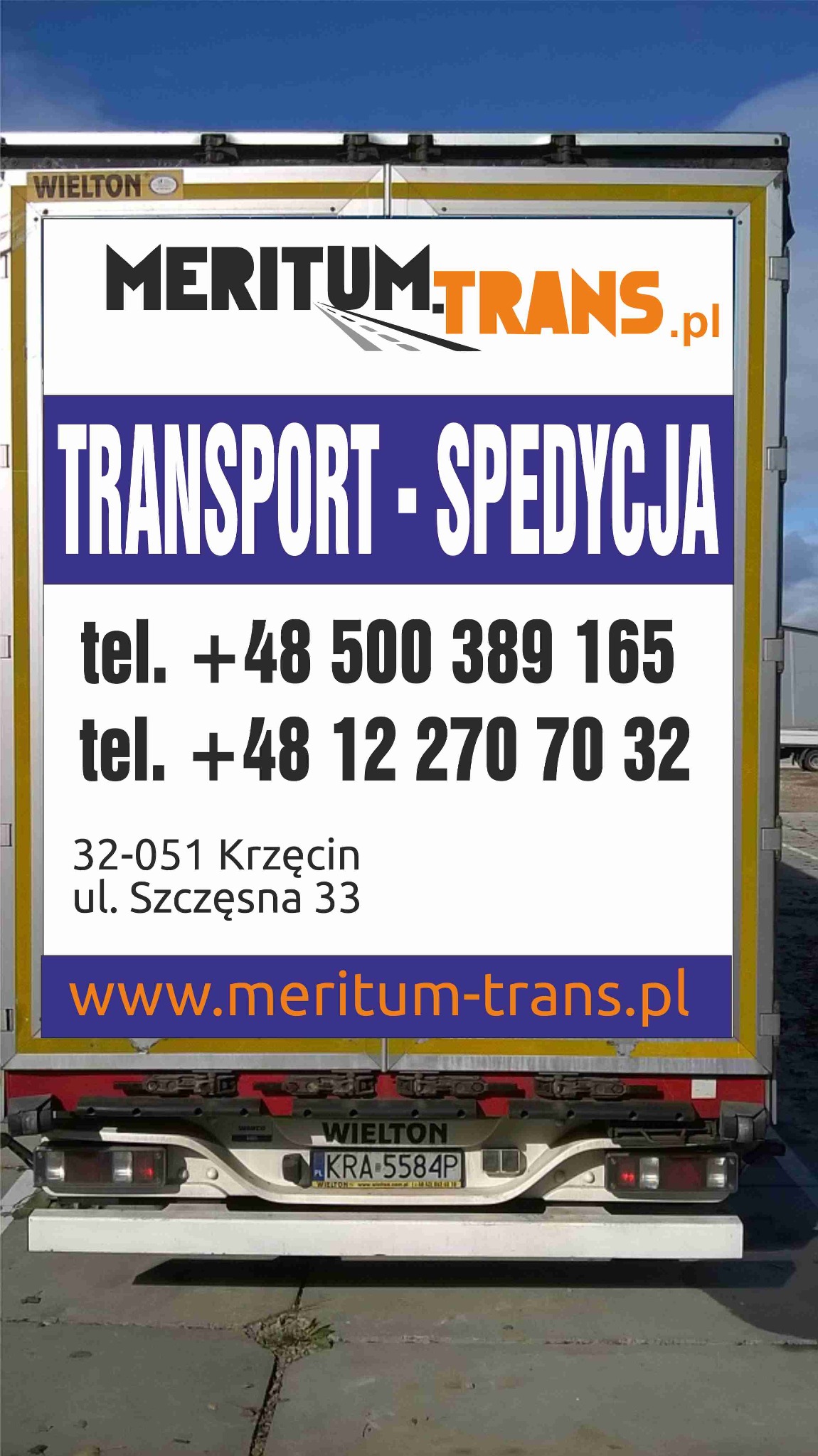 Tył naczepy z reklamą firmy transportowej Meritum Trans, zawierającą logo, dane kontaktowe i adres strony internetowej.