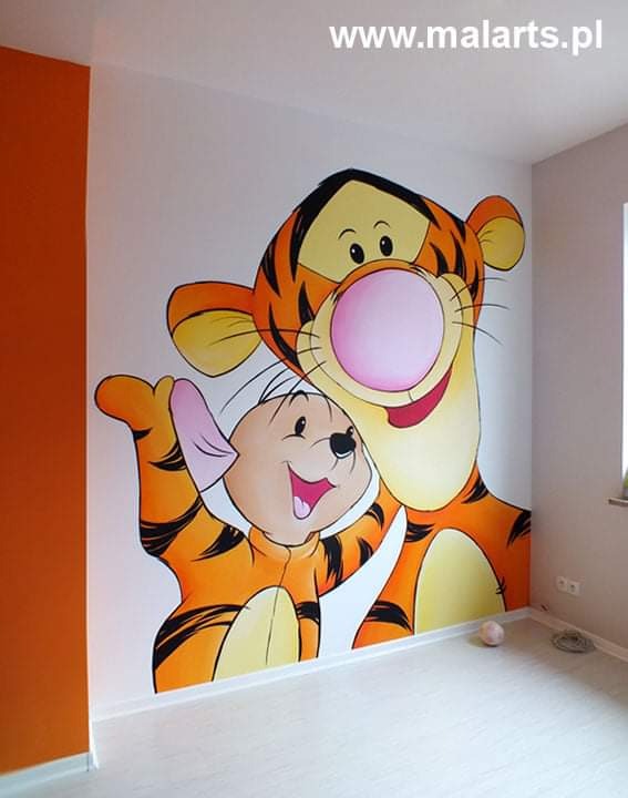Ręcznie malowana ściana w pokoju dziecięcym z postaciami z bajki Kubuś Puchatek: Tygrysek i Prosiaczek, widoczne z bliska, z jasną podłogą i pomarańczową ścianą boczną.