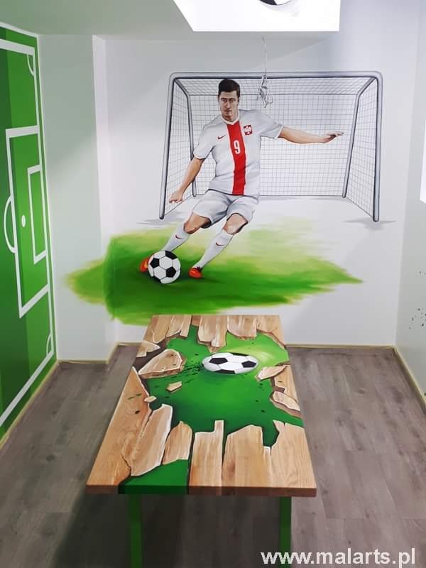 Artystyczne malowanie pokoju z motywem piłkarskim: mural z Robertem Lewandowskim i boiskiem, stół z efektem 3D pęknięcia i piłką.